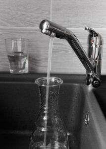 Eau du robinet dans la bouteille d'eau en verre écologique