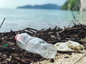 Plage avec des déchets et bouteille en plastique 